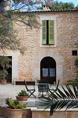 Image showing Table and chairs in front of a stone building