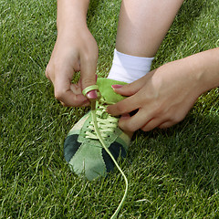 Image showing girl ties laces on shoes