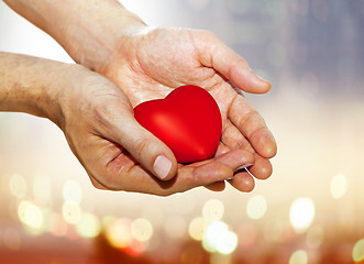 Image showing artificial red heart on hands