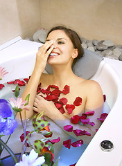 Image showing happy woman in a bath with rose-petals