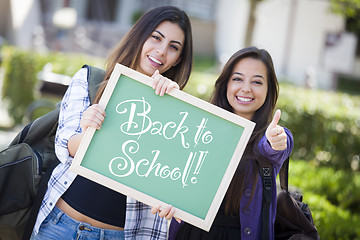 Image showing Mixed Race Female Students Holding Chalkboard With Back To Schoo