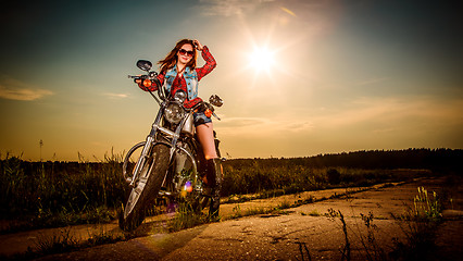 Image showing Biker girl sitting on motorcycle