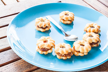 Image showing Smiling face of pineapple biscuits on wood table