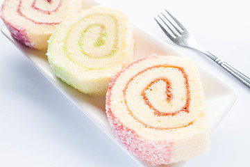 Image showing Set of colorful jam roll cakes with fork