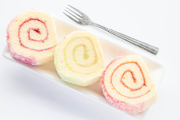 Image showing Dish of colorful jam roll cakes with fork