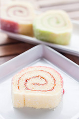 Image showing Colorful jam rolls served on wood table