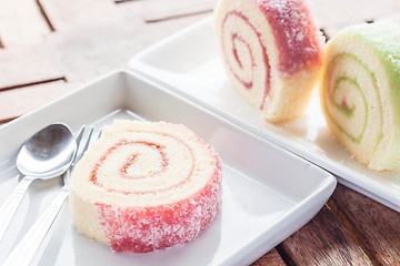 Image showing Set of colorful jam rolls with spoon and fork