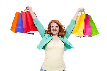 Image showing smiling young redhead girl with colorful shoppingbags 