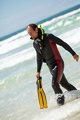 Image showing male diver with diving suit snorkel mask fins on the beach