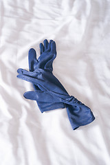 Image showing blue gloves on bed