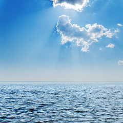 Image showing blue sea and cloudy sky with sun over it