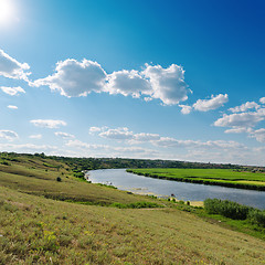 Image showing cloudy sky with sun over river