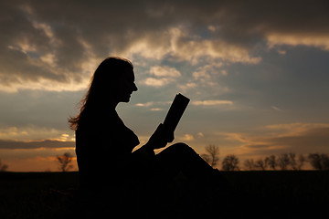 Image showing Teen girl reading book outdoors