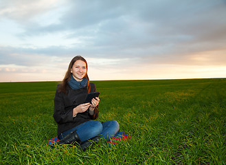 Image showing Teen girl reading electronic book outdoors