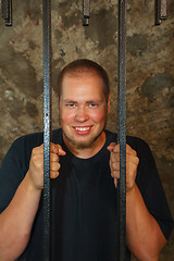 Image showing Young man behind the bars