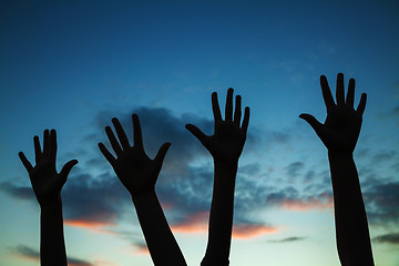 Image showing Four raised hands