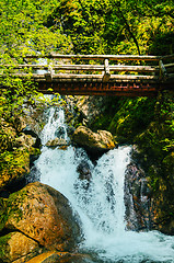 Image showing Wooden bridge over waterfalls in the mountains