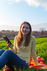Image showing Teen girl reading electronic book outdoors