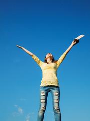 Image showing Young woman staying with raised hands