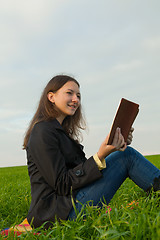 Image showing Teen girl reading the Bible outdoors