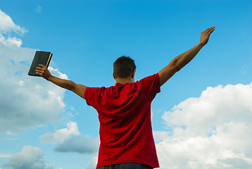 Image showing Young man staying with raised hands