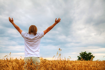 Image showing Young man staying with raised hands