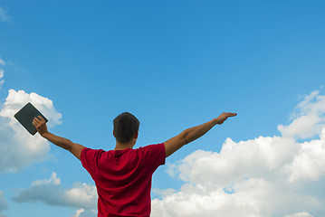 Image showing Young man staying with raised hands