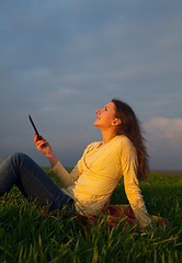 Image showing Teen girl reading electronic book outdoors