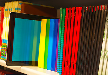 Image showing Row of colorful books and electronic book reader