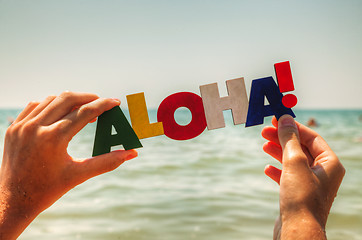 Image showing Female's hand holding colorful word 'Aloha'