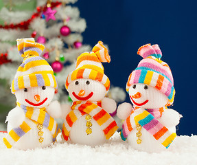 Image showing Three snowmen in front of the decorated white evergreen tree ove