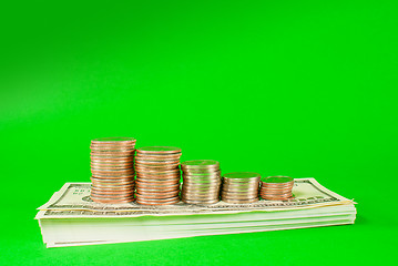 Image showing Coins stacked in bars laying on stack of 100 dollar bills