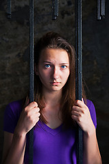 Image showing Young woman behind the bars