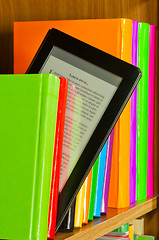 Image showing Row of colorful books and electronic book reader
