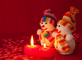 Image showing Two snowmen with two burning heart shaped candles