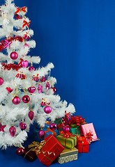 Image showing Heap of the Christmas presents under decorated white evergreen t