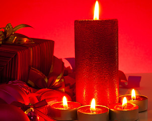 Image showing Candles and gifts over red background