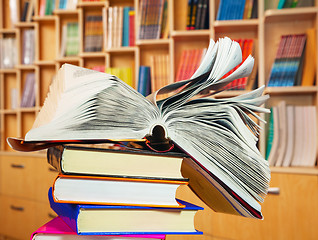 Image showing Open book on a stack of books