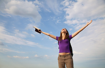 Image showing Young woman staying with raised hands