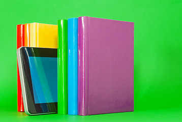 Image showing Row of colorful books and tablet PC