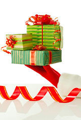 Image showing Santa's hand holding Christmas presents against white background