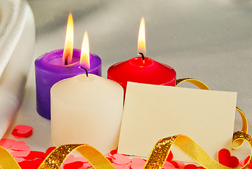 Image showing Three burning candles over light background