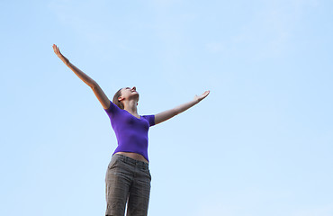 Image showing Young woman sitting with raised hand