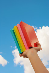 Image showing Hands holding colorful hard cover books