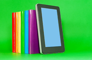 Image showing Row of colorful books and tablet PC