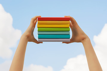 Image showing Hands holding colorful hard cover books