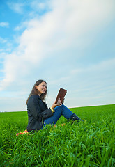 Image showing Teen girl reading the Bible outdoors