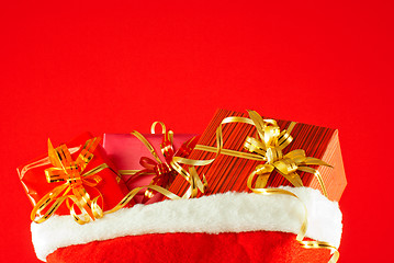 Image showing Christmas presents in the bag against red background