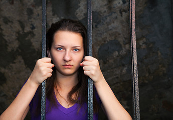 Image showing Young woman behind the bars