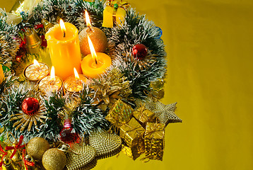 Image showing Christmas garland and burning candles over golden background